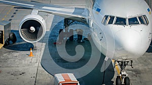 Professional mechanics in airport ground crew checking airplane chassis before flight