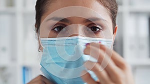 Professional medical doctor in hospital office, Portrait of young and attractive female physician in protective mask.