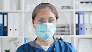 Professional medical doctor in hospital office, Portrait of young and attractive female physician in protective mask.