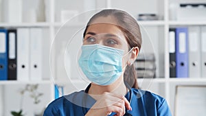 Professional medical doctor in hospital office, Portrait of young and attractive female physician in protective mask.