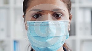 Professional medical doctor in hospital office, Portrait of young and attractive female physician in protective mask.