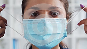 Professional medical doctor in hospital office, Portrait of young and attractive female physician in protective mask.