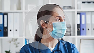 Professional medical doctor in hospital office, Portrait of young and attractive female physician in protective mask.