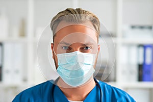 Professional medical doctor in hospital office, Portrait of young and confident physician in protective mask.