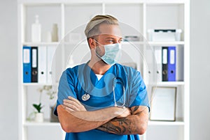 Professional medical doctor in hospital office, Portrait of young and confident physician in protective mask.