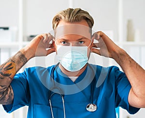 Professional medical doctor in hospital office, Portrait of young and confident physician in protective mask.