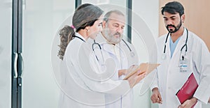 Professional Medical Doctors and team discussing in clinic hall, healthcare professionals having discussion in hospital corridor