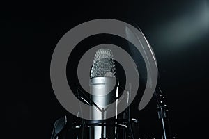 Professional microphone against black background in studio