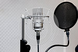 Professional microphone on the background of a light wall. Studio microphone for professional recording. Sound recording