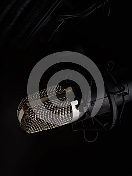Professional microphone on a black background. Minimalism. Close-up. Recording studio, music studio, vocal, concert, night club,