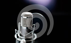 Professional microphone close up in recording studio in light.