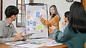 Professional Asian female graphic designer presenting her new prototype to her team. UX UI startup