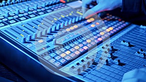 Professional mixing console is being operated by a music editor