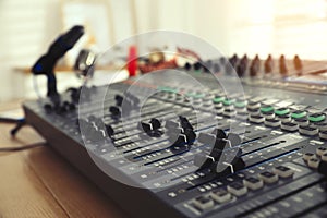 Professional mixing console on table in modern radio studio, closeup