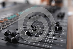 Professional mixing console on table in modern radio studio, closeup