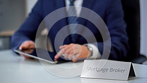 Professional mortgage broker using tablet pc, searching loan offers for client