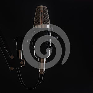 The professional music microphone in sound recording studio isolated on black background. For singers. Musical concept