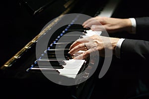 Professional musician pianist hands on piano keys of a classic piano.