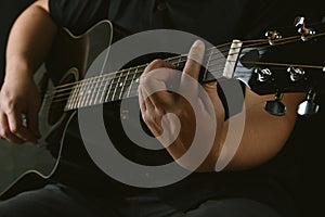 Professional musician playing acoustic guitar in music recording