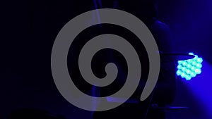 Professional musician playing drums and percussion cymbals in a dark smoky studio with blue lights. Close up of the