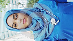 Professional Muslim medical doctor works in front of hospital office. Portrait of young and attractive Middle Eastern