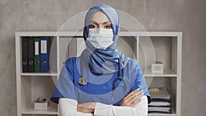 Professional Muslim medical doctor works in hospital office. Young and attractive Middle Eastern female physician in