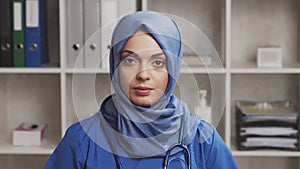 Professional Muslim medical doctor works in hospital office. Young and attractive Middle Eastern female physician