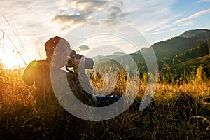 Professional nature photographer in mountain with sunset