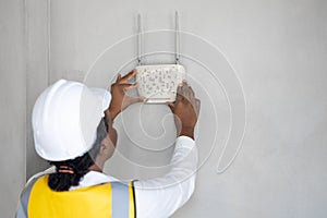 Professional network engineer installation indoor room home networking system hand placing wifi router wireless access point