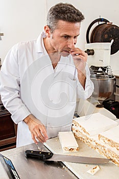 Professional nougat maker eating his fresh batch before slicing