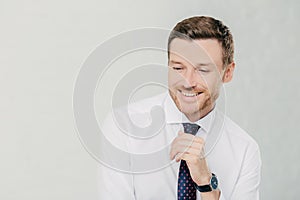 Professional office manager giggles positively, dressed in white shirt and tie. Isolated on white background. Copy space available