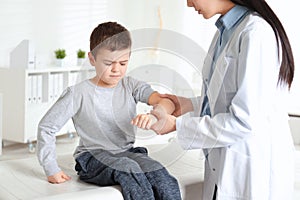 Professional orthopedist examining patient`s arm  in clinic