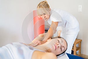 Professional osteopath manipulating arm of patient