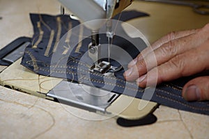Professional overlock industrial sewing machine in shoemaker workshop. Testing, debugging and fixing problems. Closeup