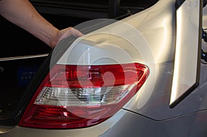 Professional Paintless Dent Repair Technician Is Repairing Dents On Car Body. Hands Of Car Mechanic. Process Of Removing