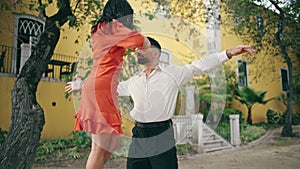 Professional pair dancing hot rumba in park. Couple latino performers moving.