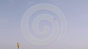 Professional parachutist flying in the blue sky. Pink parachute