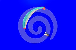 Professional paramotorist flying in the blue sky