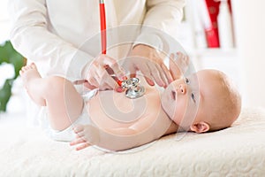 Professional pediatrician examining infant baby