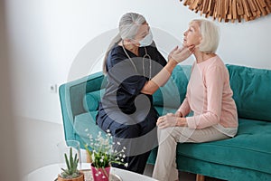 Professional pediatrician visiting senior patient at home appointment