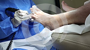 Professional pedicure. Podologist give a procedure of cleaning the toes of a customer. Close up. The concept of podology and chiro