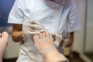 Professional pedicurist removing cuticle