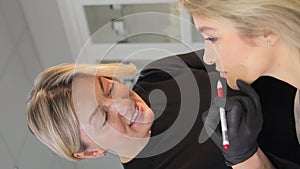 Professional permanent lip makeup in the clinic, highlighting the natural color of the lips.