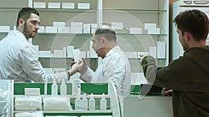 Professional pharmacist and pharmacy technician working in drugstore