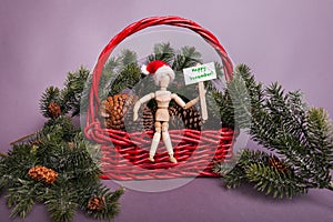 Happy December sign held by wooden jointed manikin doll wearing a red Santa Claus hat