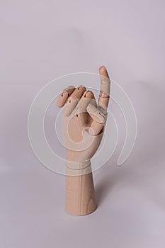 Wooden manikin hand pointing finger up as to get someones attention photo