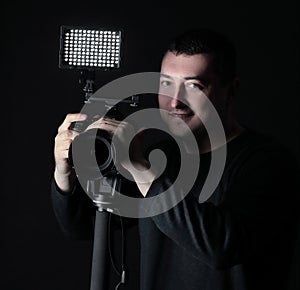 Professional photographer with camera on tripod.isolated on black background