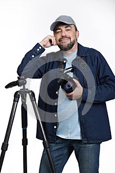 Professional photographer with camera and tripod on white background