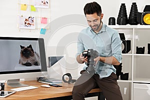 Professional photographer with camera working in modern office
