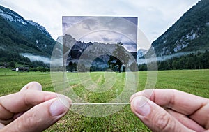 Professional photographer holding ND Gradient Filter glass appreciating an effect. Logar valley, Slovenia